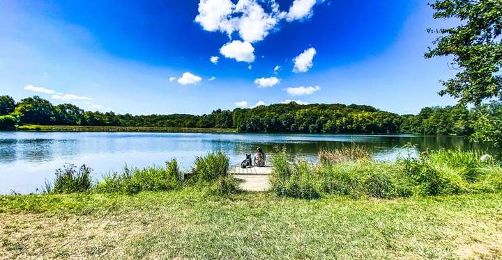 Een rustig blauw meer onder zomerwolken